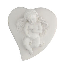 Little resin angel lying on heart