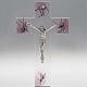 Kruzifix aus Glas mit rosa Dekorationen. s1