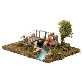 Pont miniature sur rivière avec enfant assis
