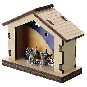 Nativity in metal with wood shack and printed desert in the background 5 cm