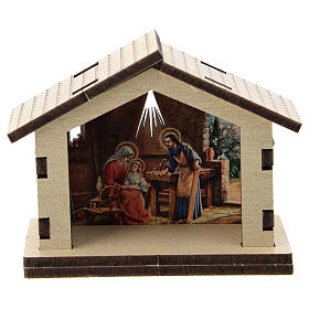 Hütte aus Holz mit Motiv der Heiligen Familie im Hintergrund