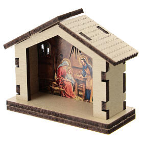 Hütte aus Holz mit Motiv der Heiligen Familie im Hintergrund