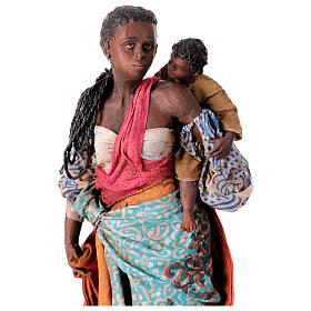 Mulher andando com criança nos braços Presépio Angela Tripi com figuras de altura média 30 cm