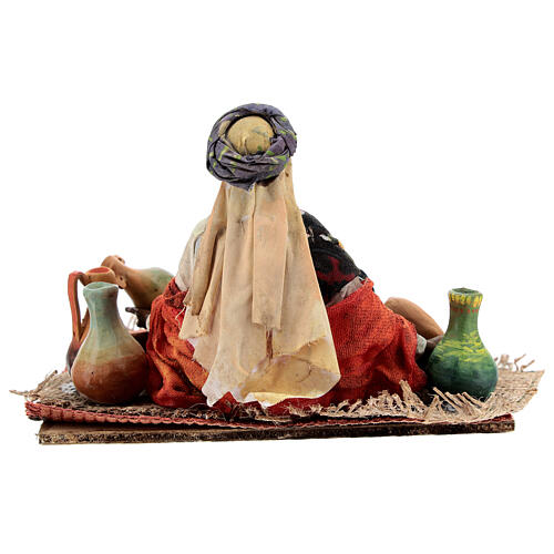 Mulher sentada vendendo objetos de cerâmica para presépio Angela Tripi com figuras de altura média 18 cm 6