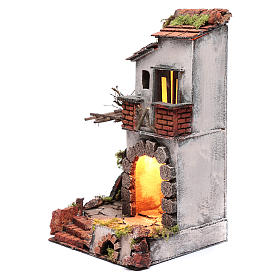 Neapolitan nativity scene setting composed by house with chimney and lights