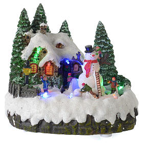 Illuminated Christmas village with moving snowman 20x20x15 cm