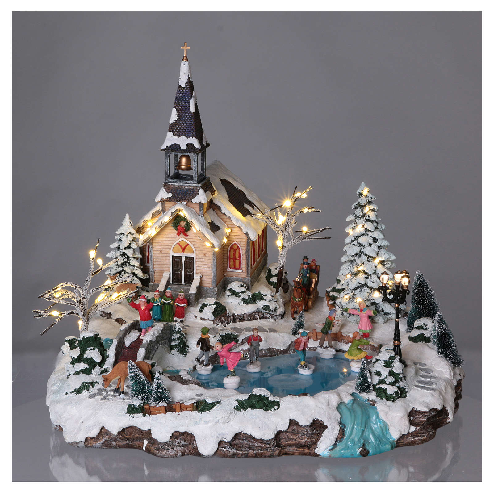 Illuminated Christmas village with animated ice skaters and | online