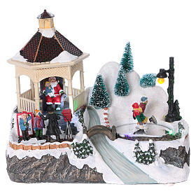 Illuminated Christmas village with animated ice skaters and Santa Claus 20x25x16 cm