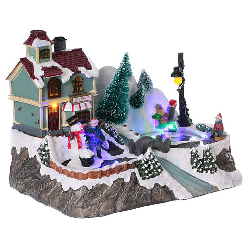 Christmas village with lights, moving ice skaters and toy shop 20x25x16 cm 4