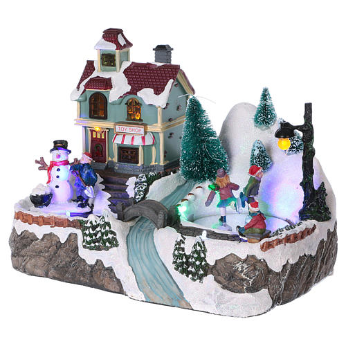 Dekoracja scenka świąteczna podświetlana ruchomi łyżwiarze sklep z zabawkami 20x25x16 cm na baterie zasilacz 3