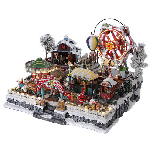 Christmas village 30x45x35 cm with moving fun fair, lights and music 3