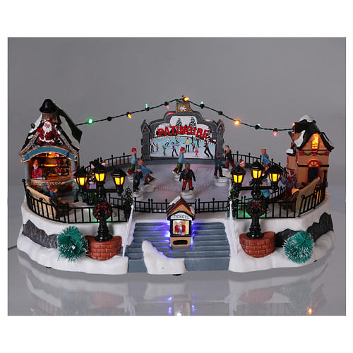 Christmas village with moving ice-skaters and Santa Claus 20x40x25 cm 2