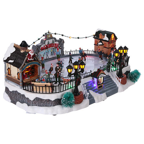 Christmas village with moving ice-skaters and Santa Claus 20x40x25 cm 4