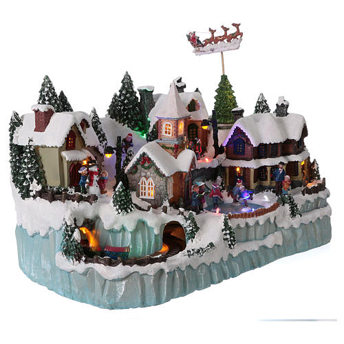 Christmas village with LED lights, ice-skaters and moving train 40x55x30 cm 4