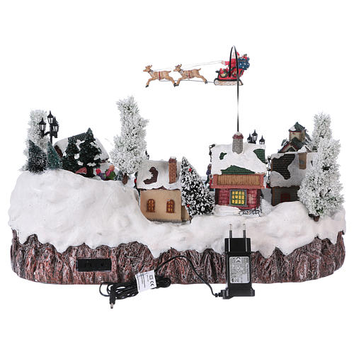 Weihnachtsdorf, mit Beleuchtung, Musik und beweglichem Weihnachtsmann und Eisläufern, 30x50x35 cm, Netzanschluss 5