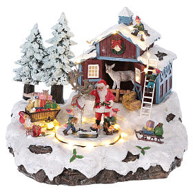 Winterszene Weihnachtsmann mit Renntier und Geschenken 20x25x20cm Licht und Bewegung