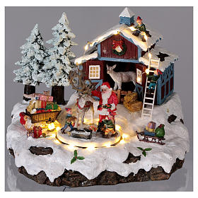 Winterszene Weihnachtsmann mit Renntier und Geschenken 20x25x20cm Licht und Bewegung
