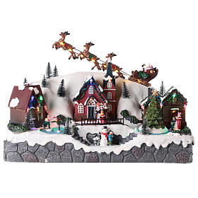 Christmas village with Santa Claus on a moving sleigh 25x40x20 cm