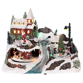 Weihnachtsdorf mit Weihnachtsmann und Kindern mit bewegten Elementen, 20x30x20 cm