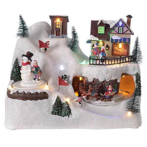 Cenário natalino em miniatura paisagem nevada com esquiadores, boneco de neve e Pai Natal, movimentos, música e luzes LED, 20x26x17 cm 1