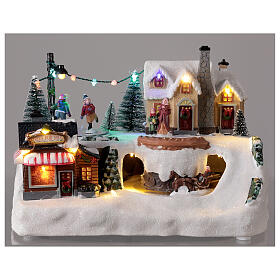 Aldeia de Natal em miniatura com patinadores e trenó, luzes LED e música, 21x29x19 cm