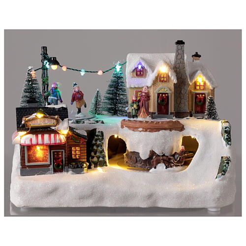 Aldeia de Natal em miniatura com patinadores e trenó, luzes LED e música, 21x29x19 cm 2
