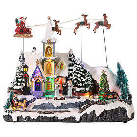 Snowy Christmas village, church with Santa in motion, LED lights, 30x35x18 cm