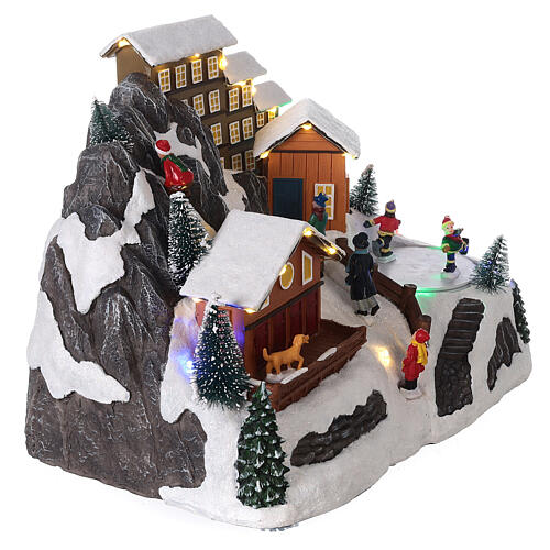 Aldeia de Natal em miniatura paisagem nevada com patinadores movimento luzes LED 20x26,5x18 cm 4