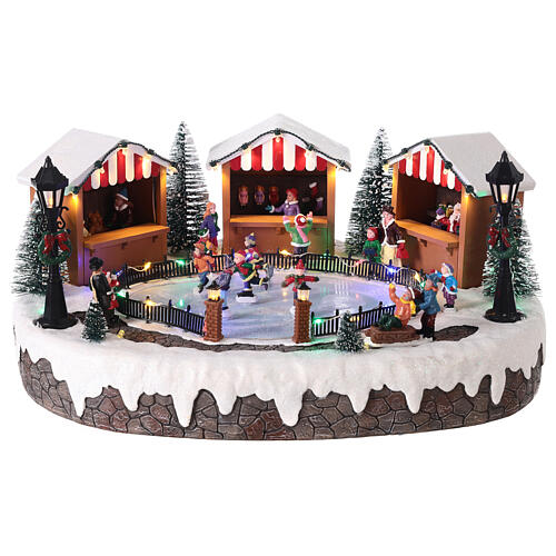 Christmas village with ice rink and figurines in motion, LED lights, 15x35x25 cm 1