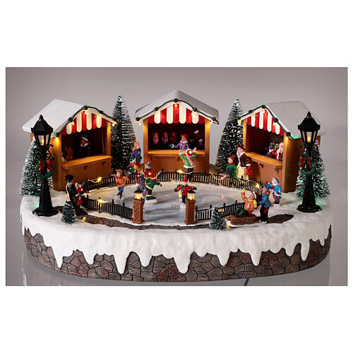 Christmas village with ice rink and figurines in motion, LED lights, 15x35x25 cm 2