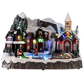 Snowy Christmas village with skiers and skaters in motion, LED lights, 25x30x20 cm
