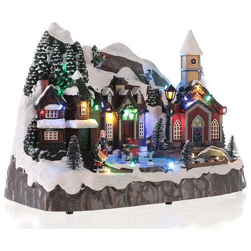 Snowy Christmas village with skiers and skaters in motion, LED lights, 25x30x20 cm 4