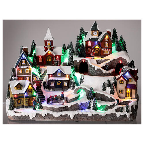 Aldeia de Natal nevada em miniatura com patinadores e comboio movimento luzes LED 36x45x26 cm 2