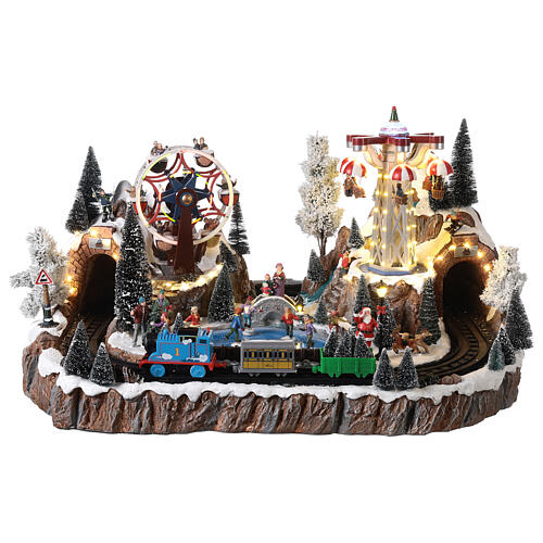 Christmas village set with train in motion, amusement park and skaters 40x70x50 cm 1