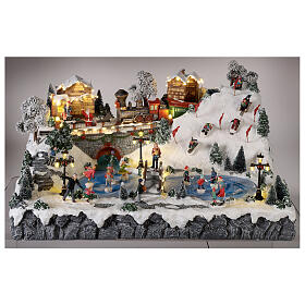 Christmas village: mountain with ice skaters, ski slope and train, motion lights and music, 30x60x50 cm