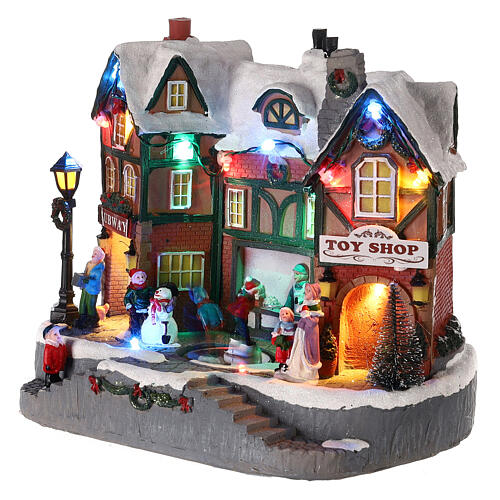 Christmas village set: building and skaters in motion 8x10x6 in 3