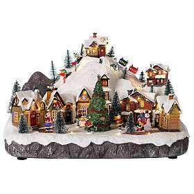 Christmas village set with skiers and Christmas tree in motion 12x16x10 in