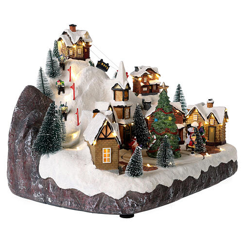 Christmas village set with skiers and Christmas tree in motion 12x16x10 in 5