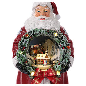 Santa Claus with miniature Christmas village, train in motion, 12x6x6 in