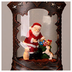 Boule à neige électrique botte cowboy Père Noël lumières musique 35x20x10 cm