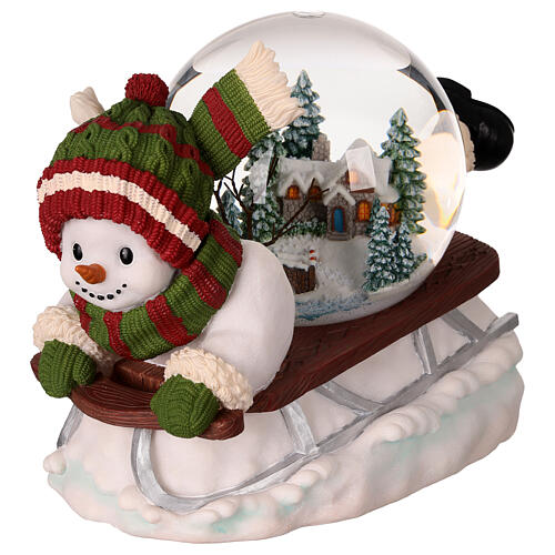 Snow globe: snowman on a sled with lights, music and automatic snowfall, 6x8x6 in 1