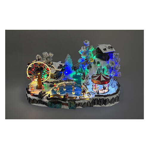 Pueblo navideño LED con teleférico, patinadores y noria 65x45x31 cm 2