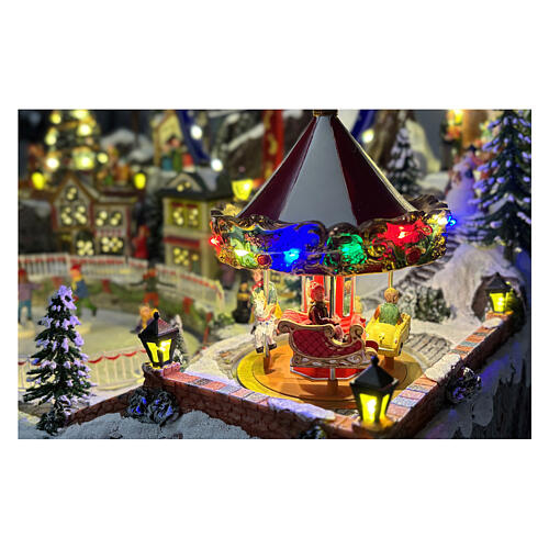Aldea Navideña deluxe con patinadores, tren, trineo y atracciones en movimiento LED y música 65x55x45 cm con corriente 3