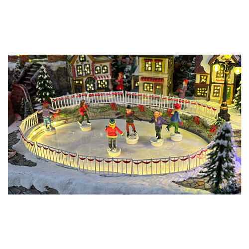 Aldea Navideña deluxe con patinadores, tren, trineo y atracciones en movimiento LED y música 65x55x45 cm con corriente 9