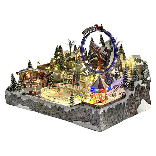 Villaggio Natalizio deluxe pattinatori giostre movimento LED musica 65x55x45 cm corrente 10