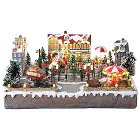 Christmas Village: colourful city with skaters and carousel in motion, LED lights, 24x20x10 in, electricity