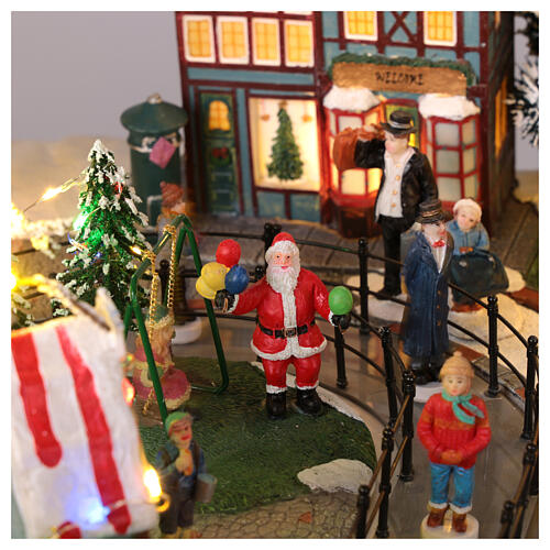 Pueblo navideño ciudad patinadores carrusel movimiento LED coloridos 60x50x25 cm eléctrico 10