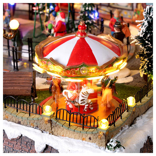 Pueblo navideño ciudad patinadores carrusel movimiento LED coloridos 60x50x25 cm eléctrico 12
