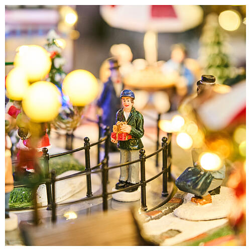 Pueblo navideño ciudad patinadores carrusel movimiento LED coloridos 60x50x25 cm eléctrico 12