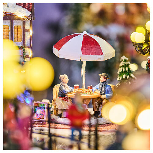 Cenário natalino cidade com patinadores carrossel movimento LEDs coloridos 60x50x25 cm corrente 12